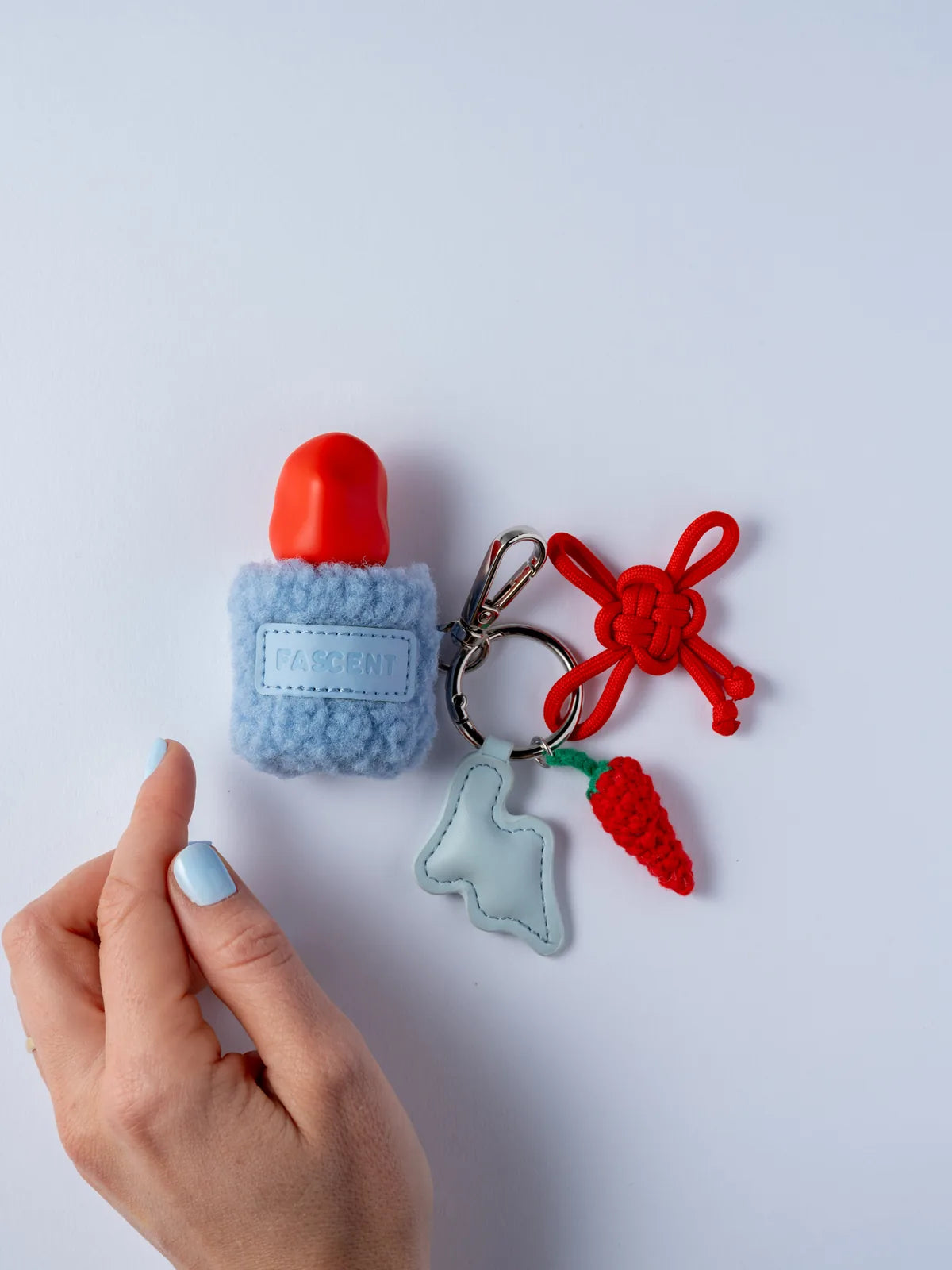 Étui bouclette bleue avec ses charms, dont un piment au crochet